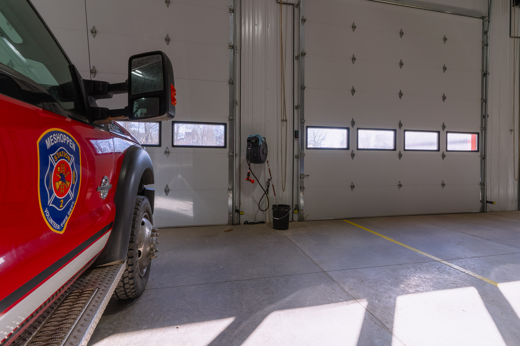 White insulated windows and man doors with flush panel finish in fire department pole barn