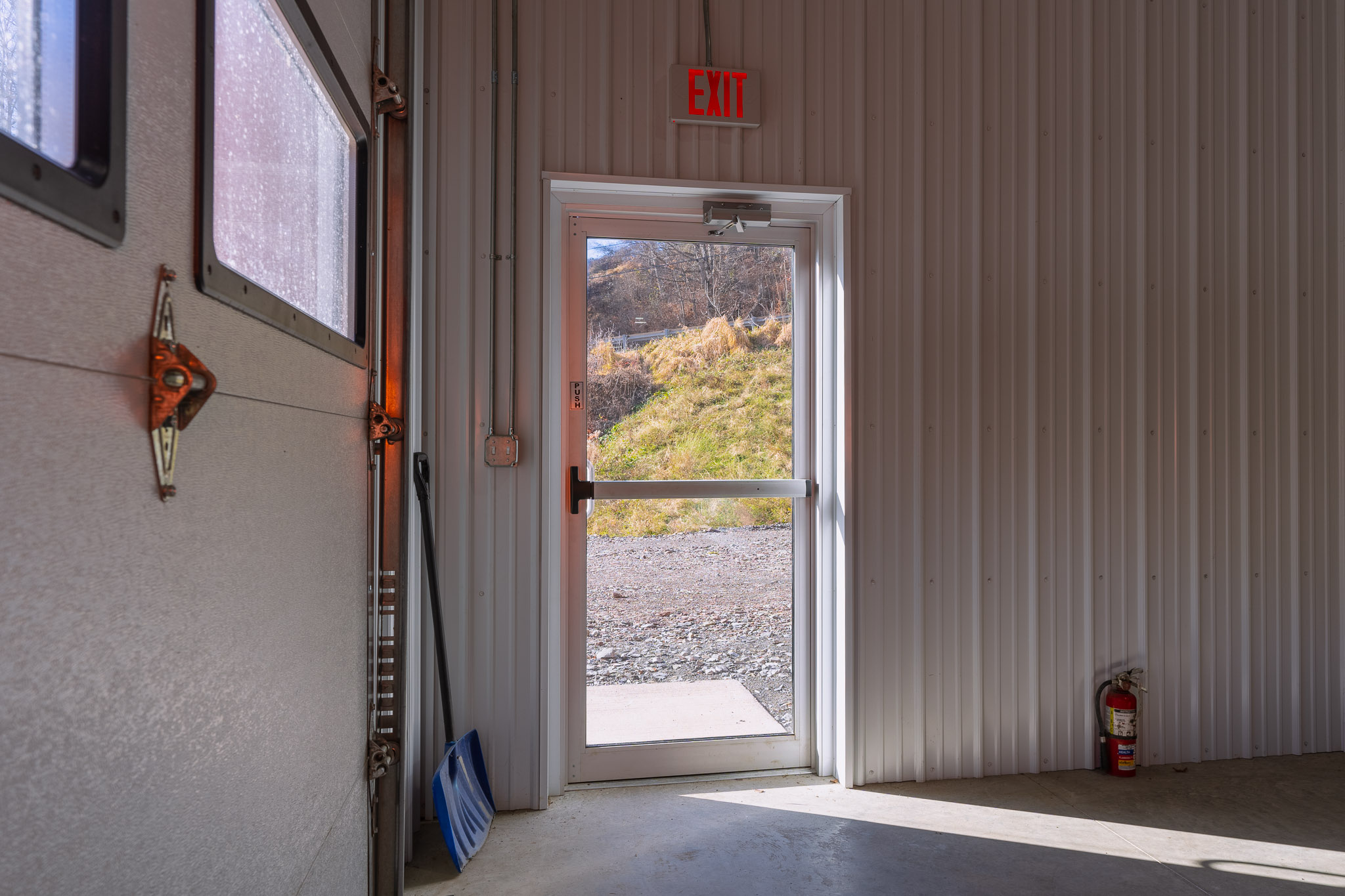 Commercial entry doors with panic bars and full glass at Meshoppen Fire Department pole barn
